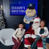 Brother and sister smile with Santa and Louie standing
